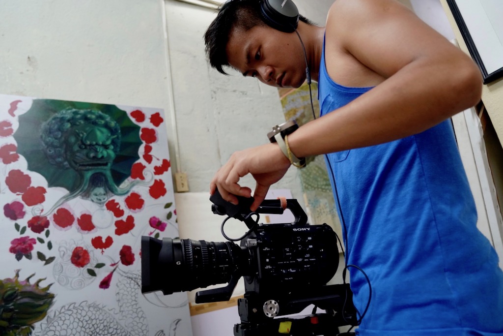 Photo of Matthew Tan working with a film camera